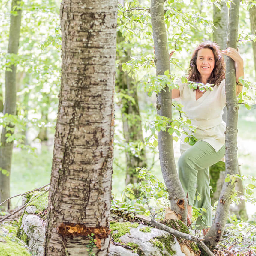 Wyda -Trainerin Barbara Poetsch im Wald zwischen den Bäumen im Wyda-Gewand